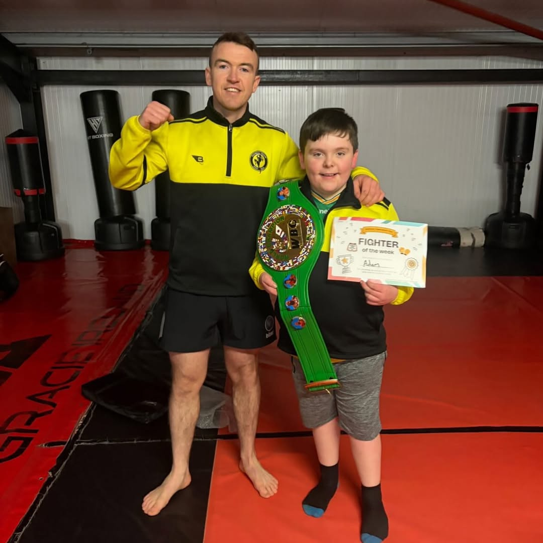 Coach Seamus with student holding Fighter of the Month award